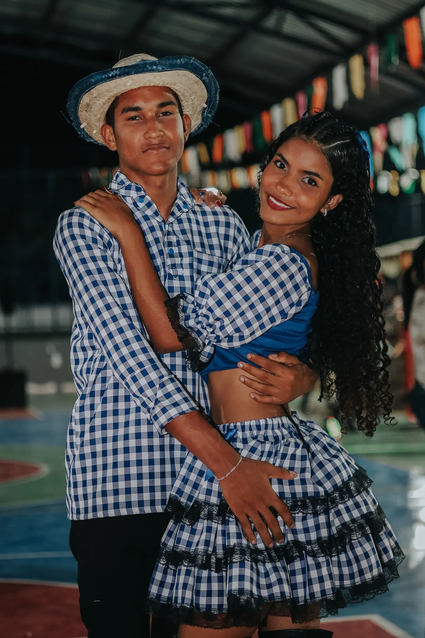 Casal de quadrilha junina abraçado com roupas xadrez